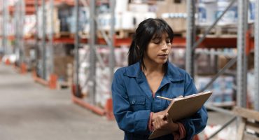 trabajadora-tomando-notas-en-un-almacen