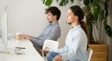 Mindful calm young woman taking break in office for meditation